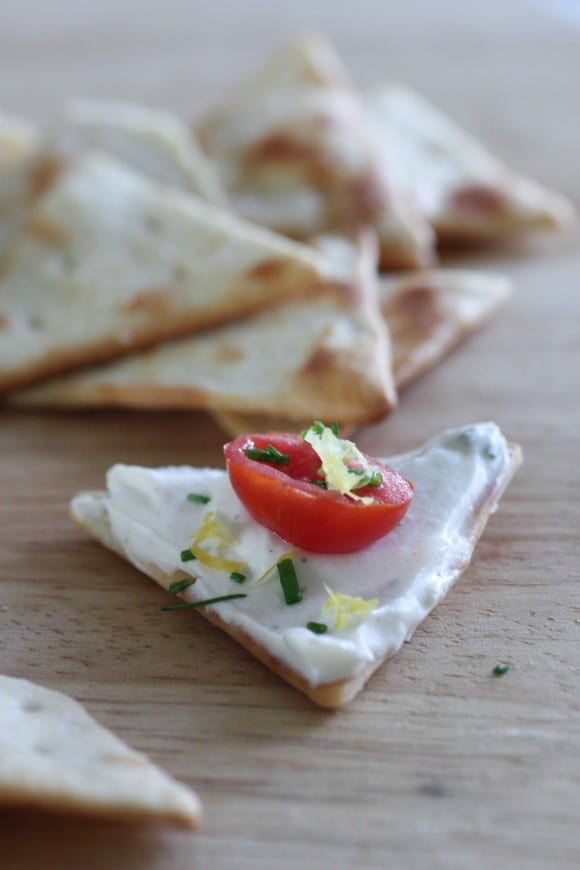 Lemon chive goat cheese dip on a cracker with tomatoes | CatchMyParty.com