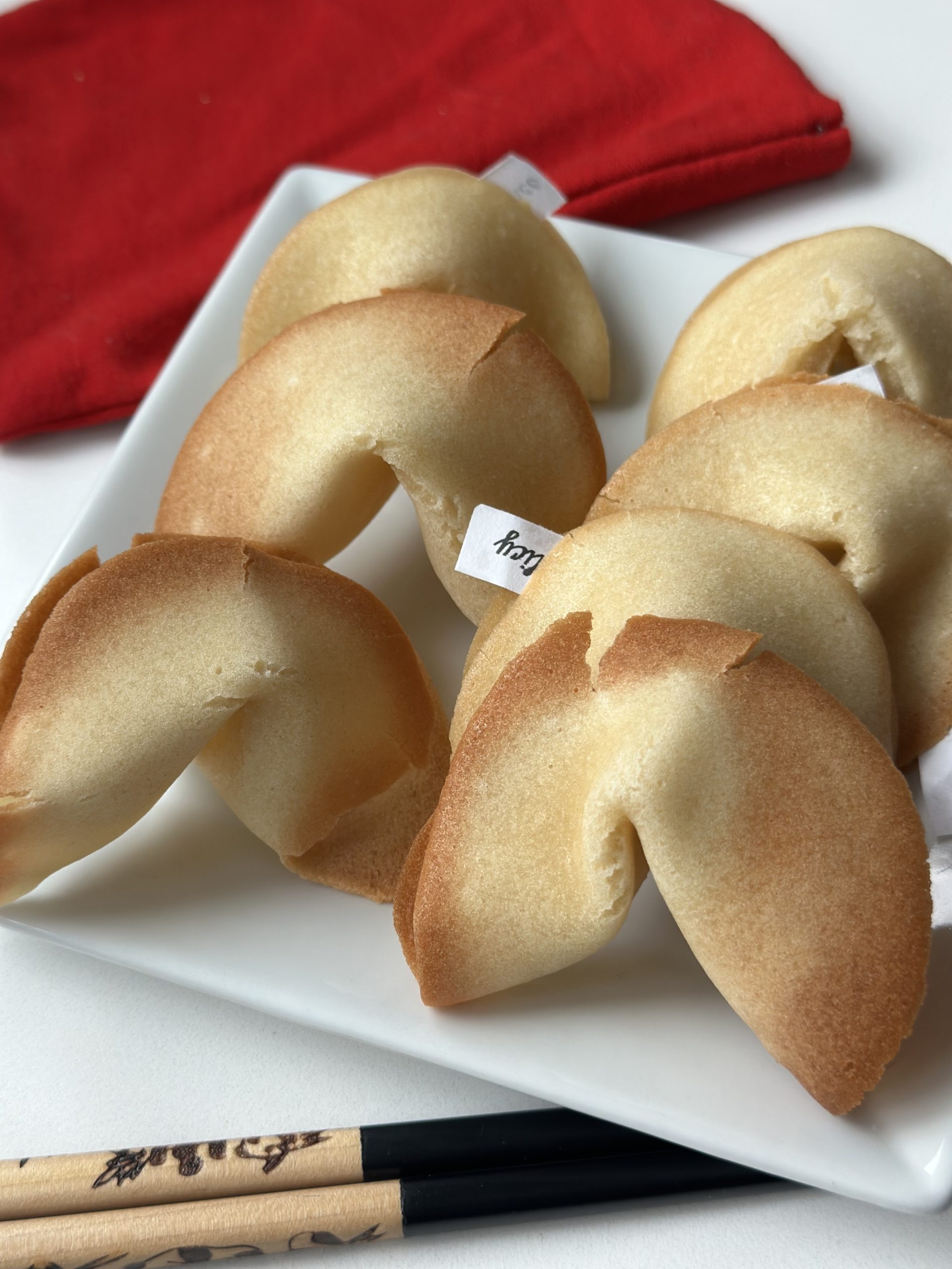 Photo of homemade fortune cookies on a plate with chopsticks