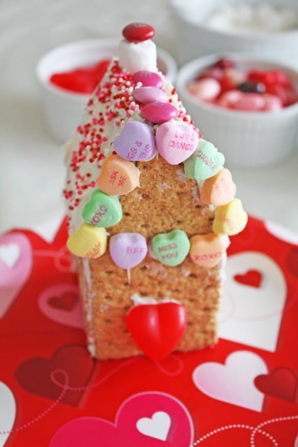 Make a cute chimney, add a dab of frosting to a mini marshmallow, and top it with a single M&M. Lastly, place a large heart gummy for the door and some sweethearts to frame the roof. See more party ideas and share yours at CatchMyParty.com