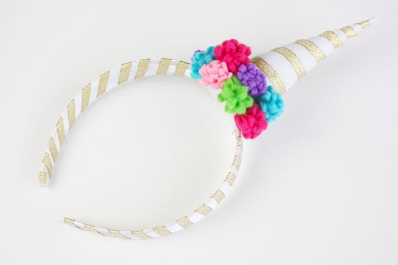 Glued the mini pompom flowers around the base of the horn | CatchMyParty.com