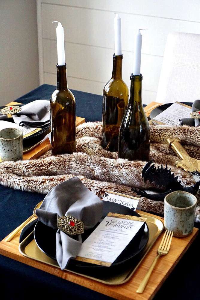 The incredible dining table with Jon Snow's fur placed a centerpiece decorated with a dragon, the 3 eyed raven, a valyrian sword and a Lannister shield