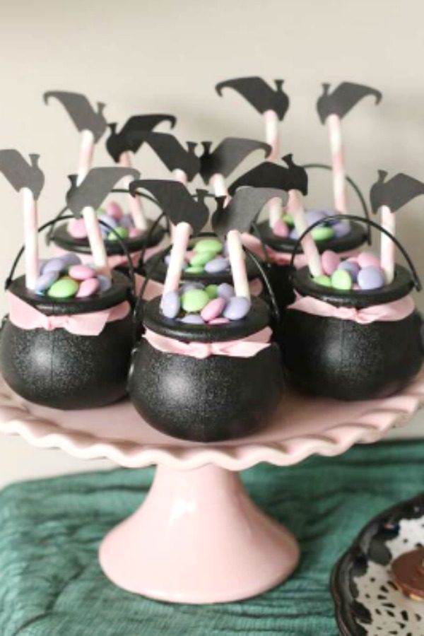 Mini cauldrons full of candy with an upside down witch sticking out