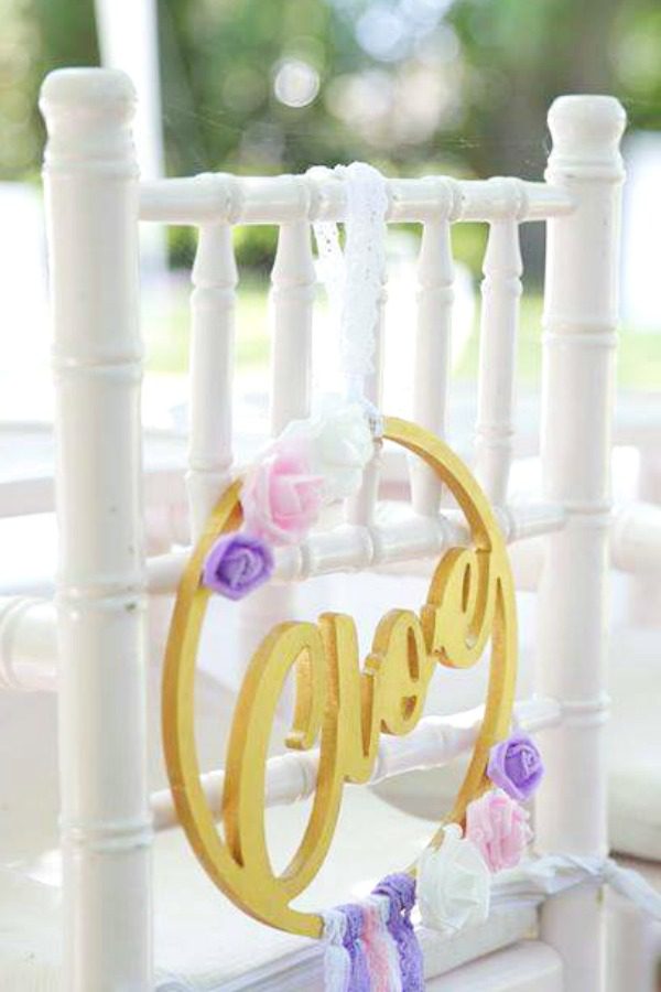 Beautiful personalized name decorations hanging on each chair at this wonderful boho chic baptism