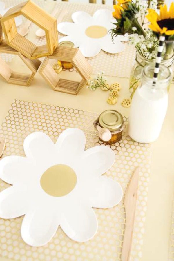 Pretty table settings with flower paper plates and honeycomb inspired placemats